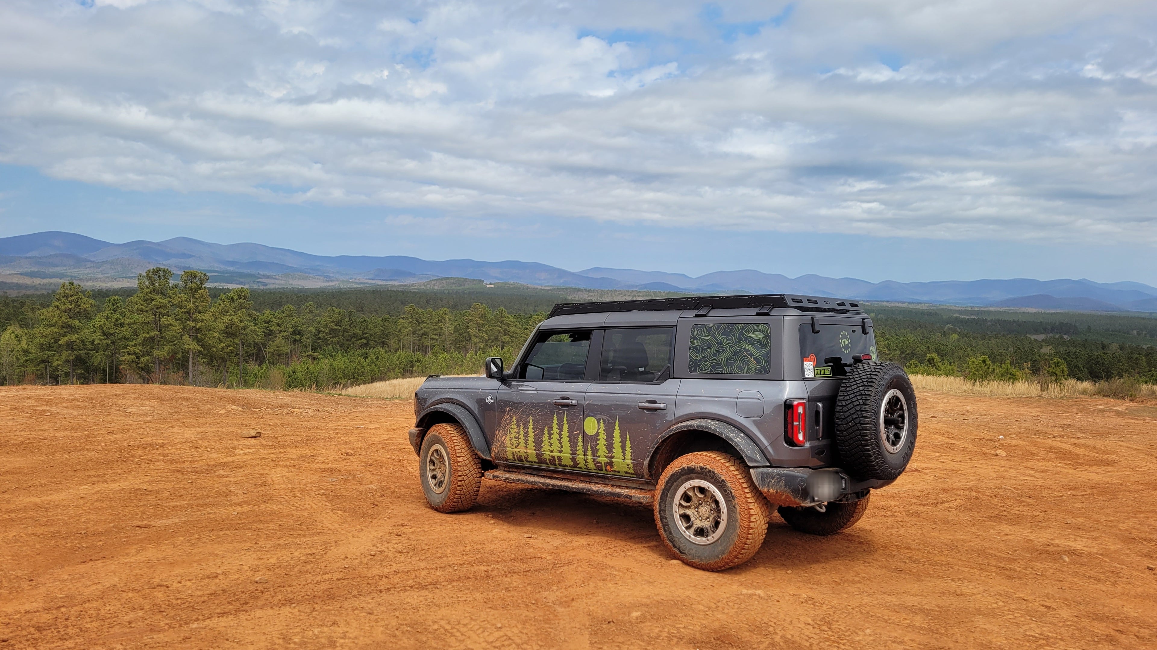 Ford Bronco parked on dirt road.